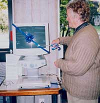 Daphne Crampton, secretary of the Friends of Christchurch City Libraries, officially launches the Smart View Reader with a cut of a pair of scissors.
