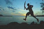 In October, the Melbourne 2006 Queen’s Baton was on a relay through Vanuatu. Former athletic champion Tawai Keiruan takes a leap as he carries the baton near Port Vila.