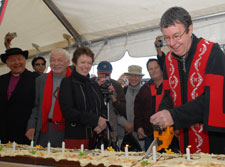 Mayor Garry Moore uses a chain saw to cut the 150th birthday cake, watched by Bishop David Cole, Rik Tau, Ngai Tahu and Mayoress Pam Sharpe.