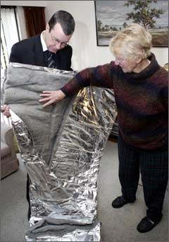 Mayor Garry Moore visits Mrs Merryl (Betty) Smith on Monday to inspect the energy saving measures installed as part of Meridian's Energy Saver Vans programme. The free installations were done in partnership with Community Energy Action and EnergySmart. Here, they inspect a hot water cylinder cover