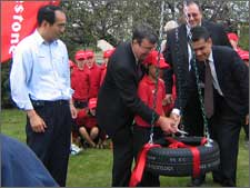 Mayor Garry Moore accepting, on behalf of the city, a tyre swing presented to the children of Christchurch by Firestone Ltd, to celebrate the production of the 35 millionth tyre made at the Firestone factory in Papanui.